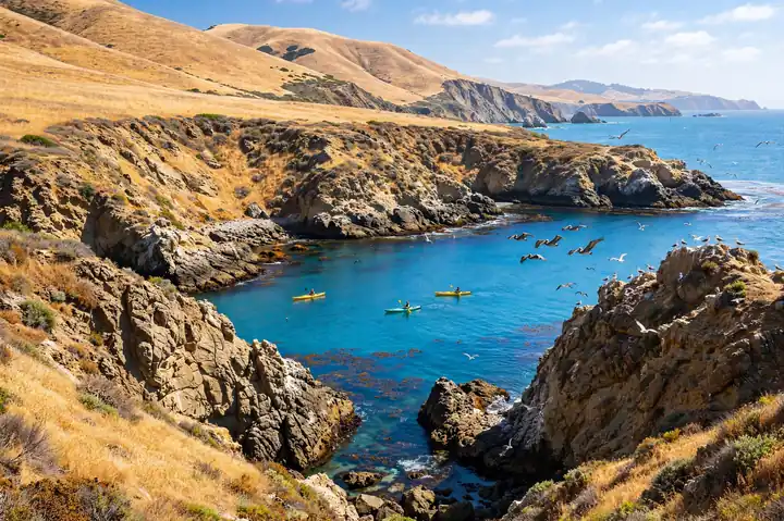 Channel Islands National Park sea cliffs and turquoise cove with kayaks in California